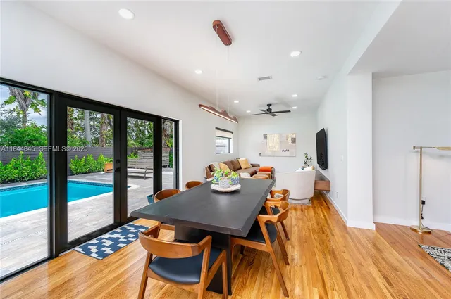 a view of a dining room with furniture a chandelier and wooden floor