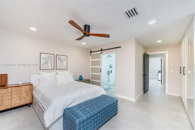 a bedroom with a large bed and a chandelier