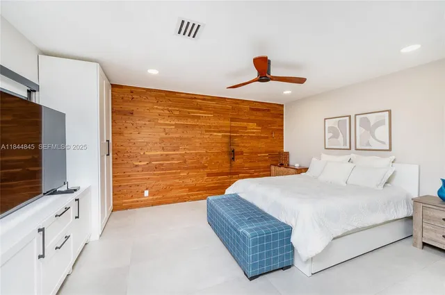 a bedroom with a bed and a flat screen tv