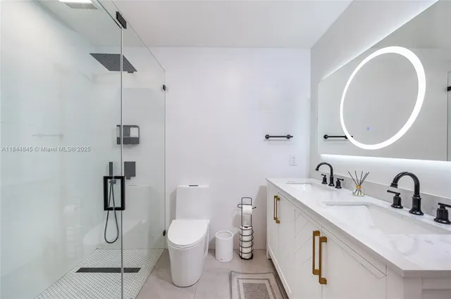 a bathroom with a double vanity sink toilet and shower