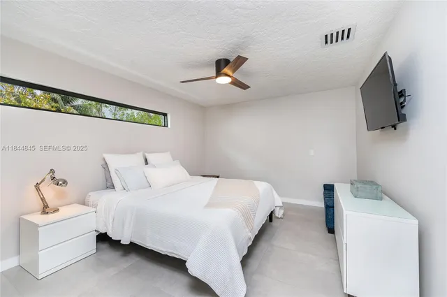 a bedroom with a bed and a ceiling fan