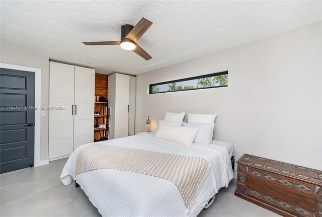 a bedroom with a bed and a ceiling fan