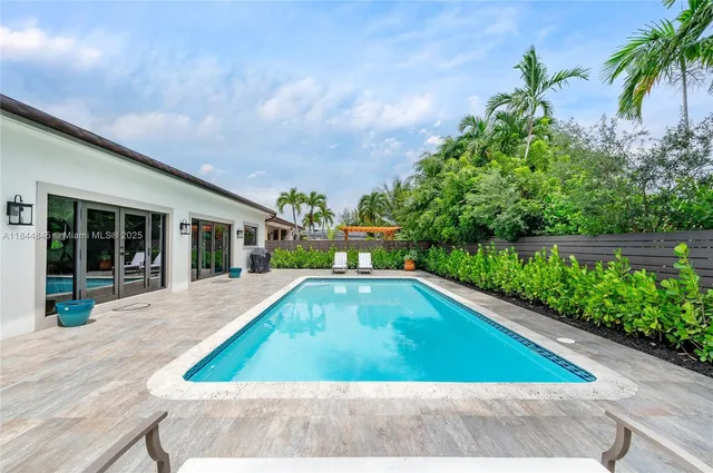 a view of swimming pool on a sunny day with lawn chairs