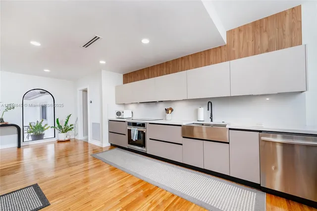 a kitchen with stainless steel appliances granite countertop a sink and a stove