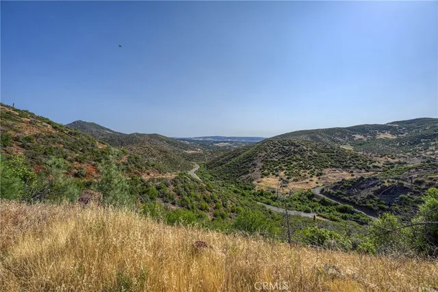 a view of a dry yard with mountains in the background