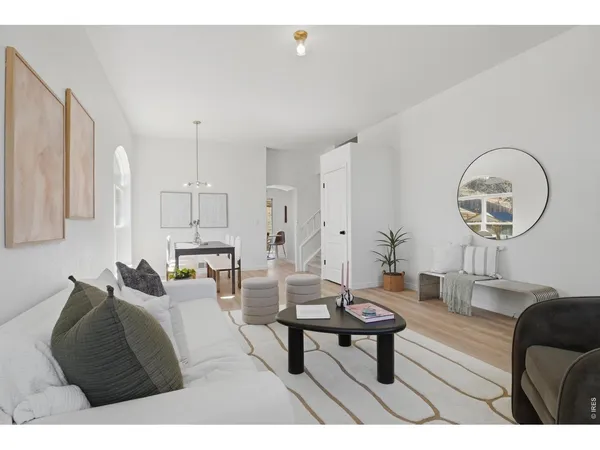 a living room with furniture a mirror and a wooden floor