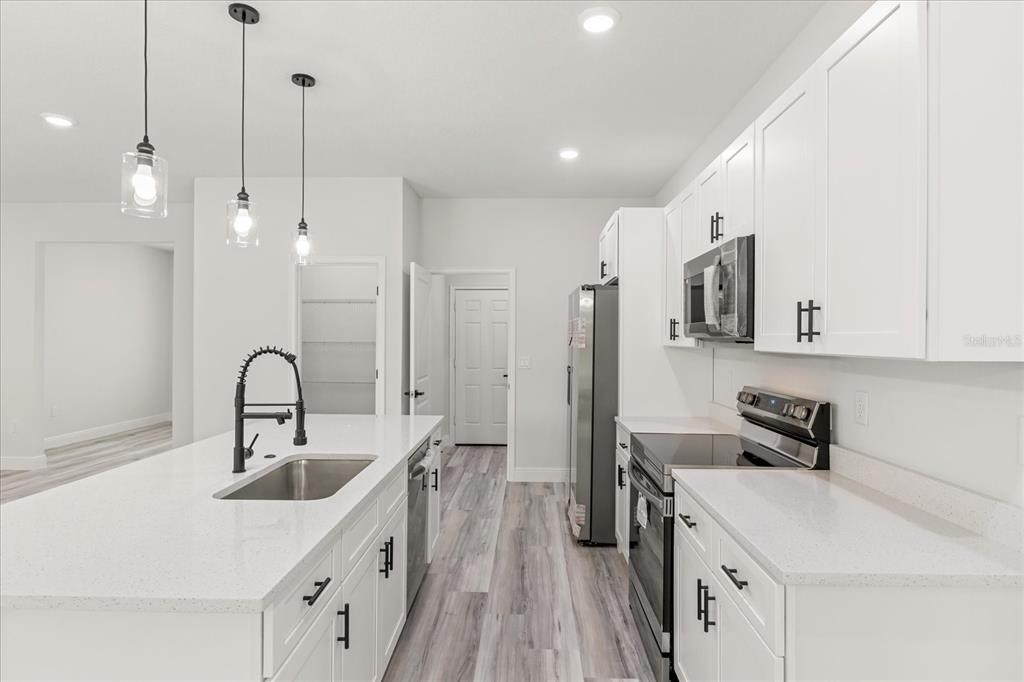 2097 Southwest 153rd Loop Ocala, FL 34481 - Photo 17 of 39 a kitchen with stainless steel appliances granite countertop a sink stove and refrigerator