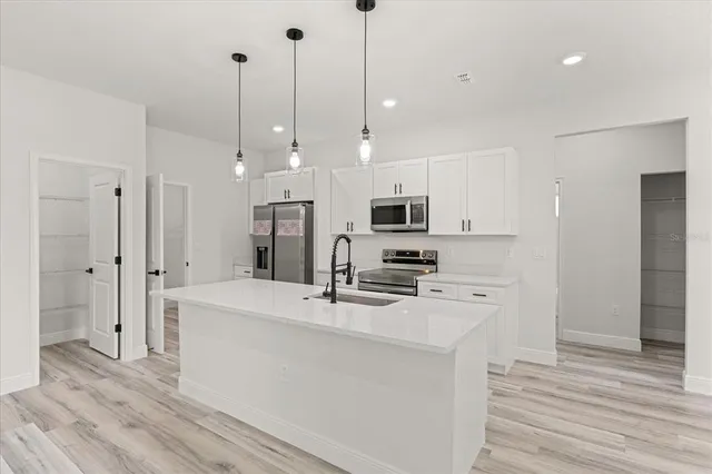 a kitchen with white cabinets and sink