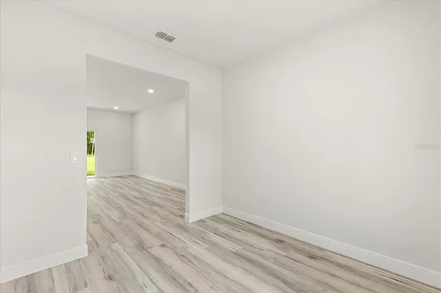 a view of a hallway with wooden floor and a window