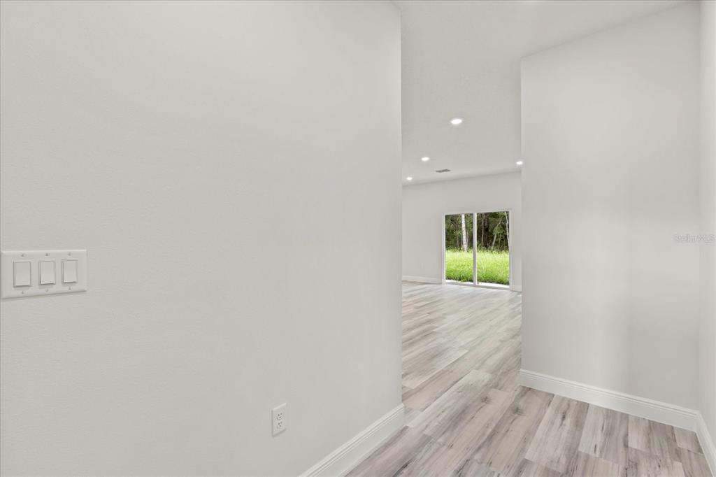 2097 Southwest 153rd Loop Ocala, FL 34481 - Photo 23 of 39 a view of a hallway with wooden floor and a window
