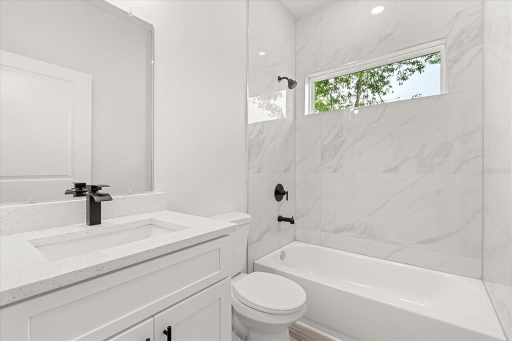 2097 Southwest 153rd Loop Ocala, FL 34481 - Photo 32 of 39 a bathroom with a granite countertop sink a toilet and bathtub