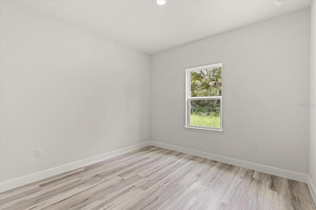 2097 Southwest 153rd Loop Ocala, FL 34481 - Photo 38 of 39 an empty room with wooden floor and windows