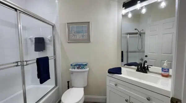 a bathroom with a sink a toilet a shower and a mirror