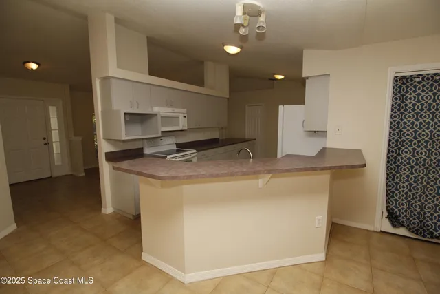 a kitchen with stainless steel appliances granite countertop a sink a stove a refrigerator a center island a stove and a window