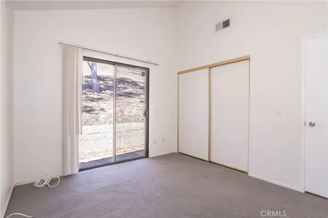 an empty room with a fireplace and large window