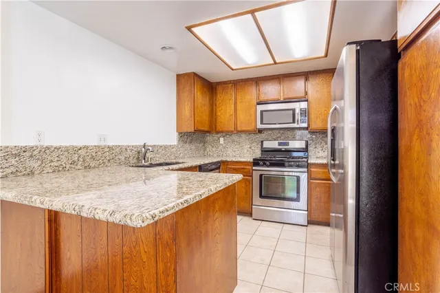 a kitchen with stainless steel appliances granite countertop a stove a sink and a refrigerator
