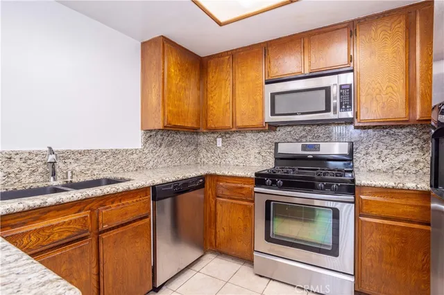 a kitchen with stainless steel appliances granite countertop a stove microwave and sink