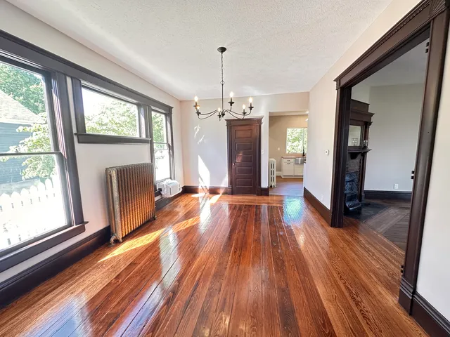 a view of a room with wooden floor staircase and a kitchen