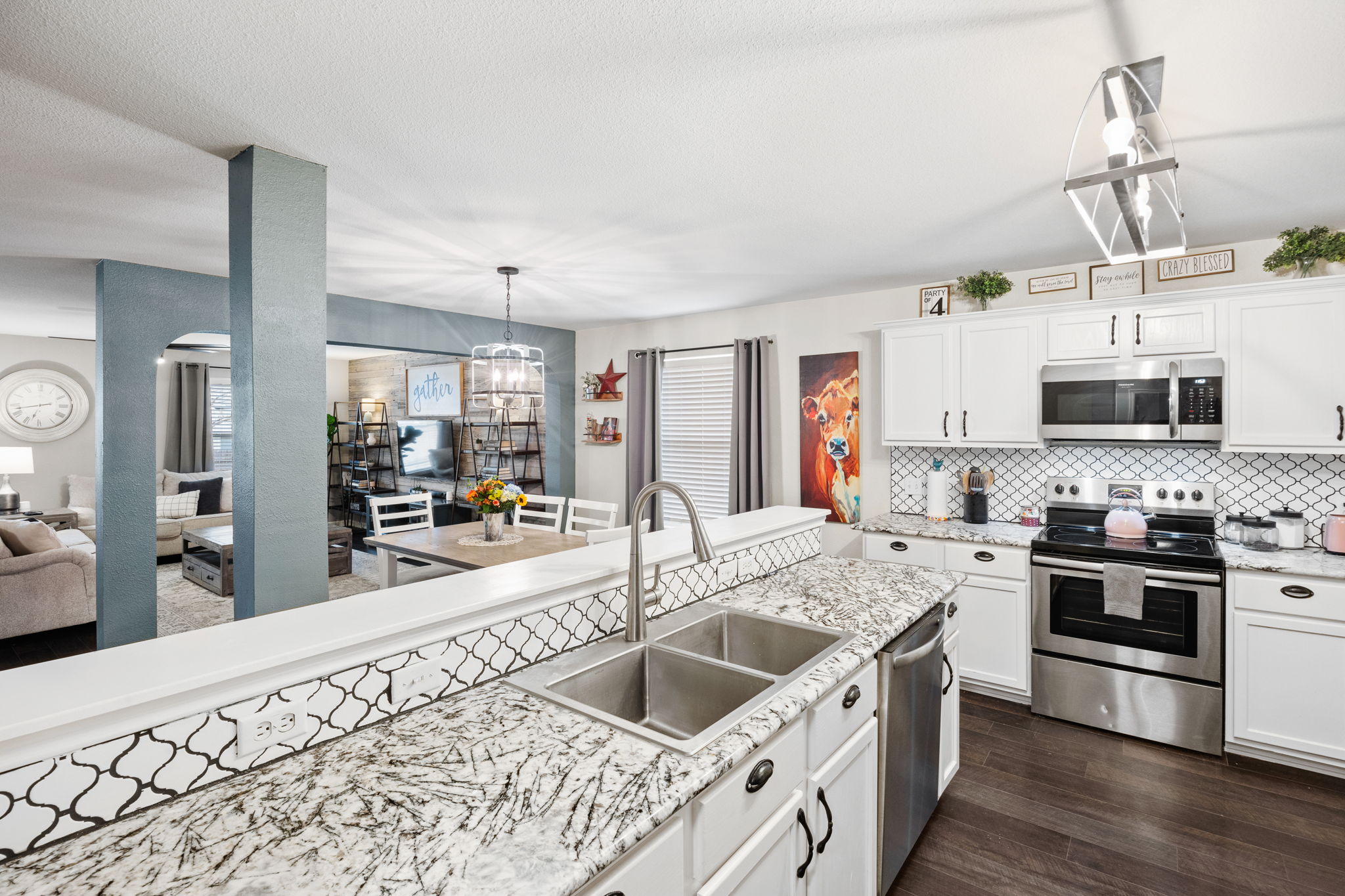 304 Old Peak Road Georgetown, TX 78626 - Photo 40 of 40 Kitchen with stainless steel appliances, white cabinetry, open floor plan, a chandelier, and tasteful backsplash