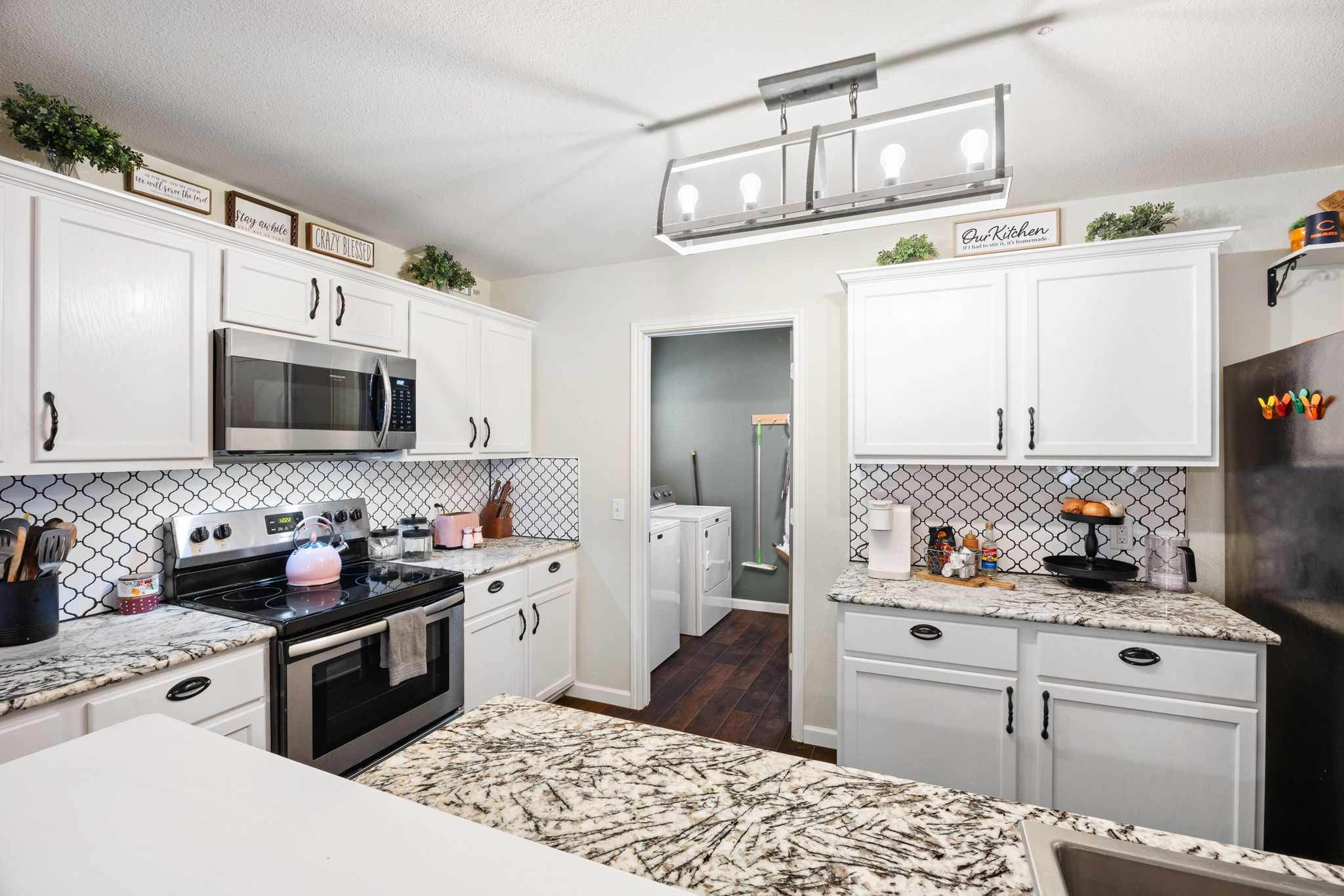 304 Old Peak Road Georgetown, TX 78626 - Photo 12 of 40 Kitchen featuring stainless steel appliances, white cabinetry, and independent washer and dryer