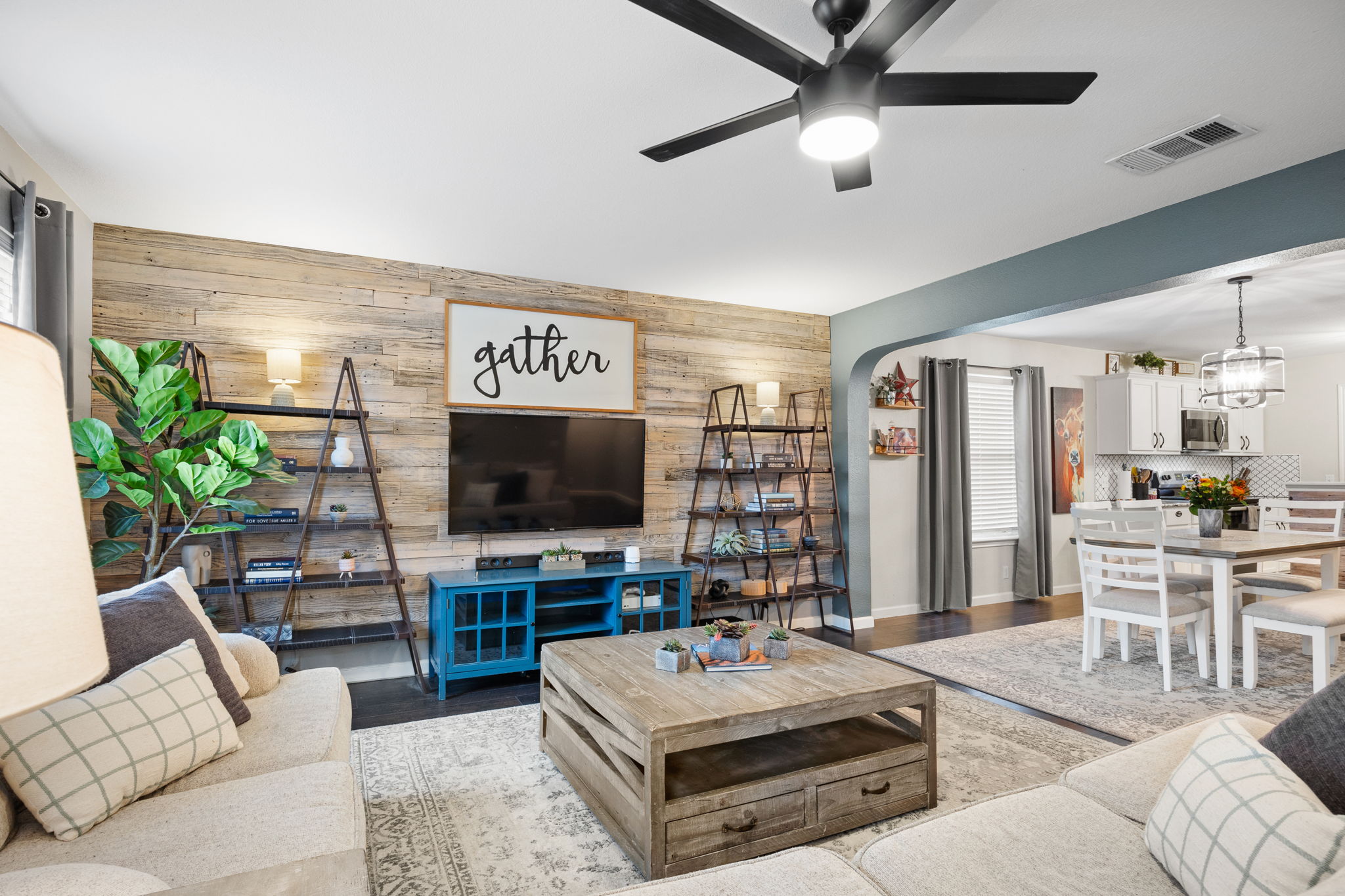 304 Old Peak Road Georgetown, TX 78626 - Photo 6 of 40 Living area with wooden walls, wood finished floors, ceiling fan, an accent wall, and arched walkways