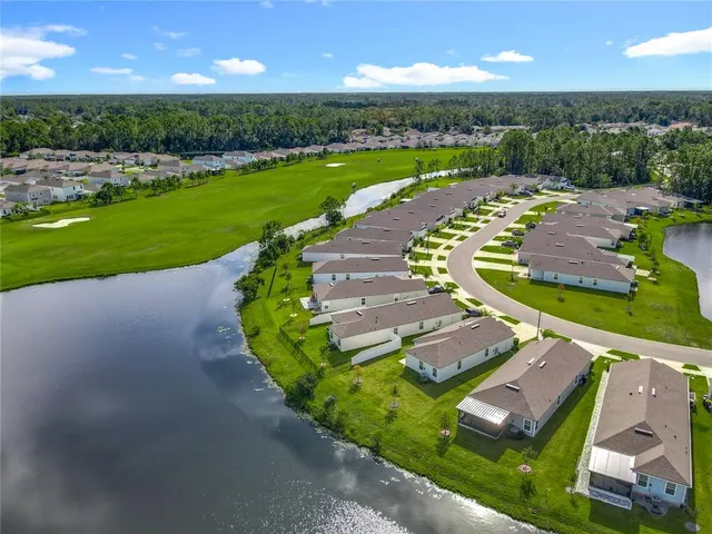 an aerial view of residential houses with outdoor space and lake view