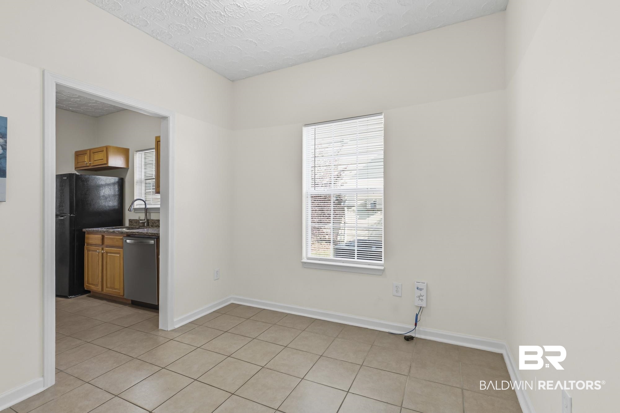 1153 Sloane Cove Foley, AL 36535 - Photo 11 of 25 Unfurnished dining area featuring a textured ceiling, plenty of natural light, and light tile patterned floors