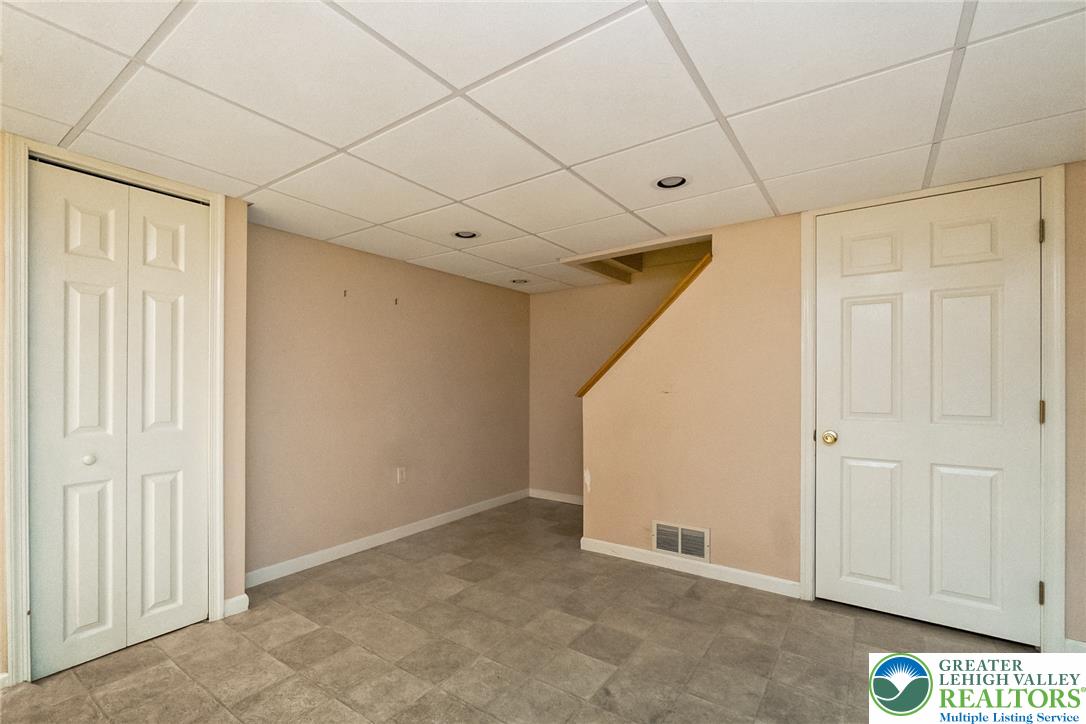 268 Apollo Drive Bethlehem, PA 18017 - Photo 36 of 56 A versatile basement space offering potential for customization, featuring vinyl flooring and access to a staircase.