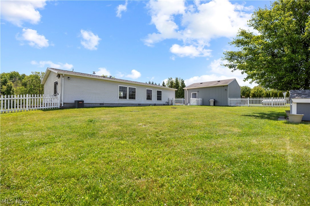 294 Twp 150 Road Sullivan, OH 44880 - Photo 2 of 39 Expansive green lawn with a white picket fence enclosing a portion of the property