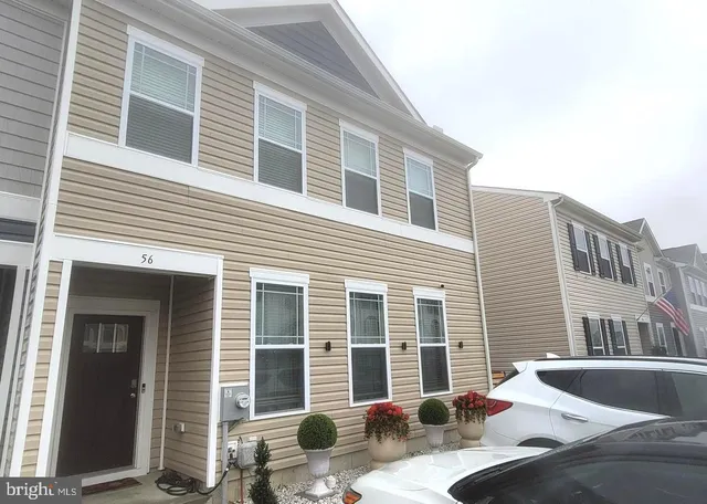 a view of a brick house with chairs in front of house