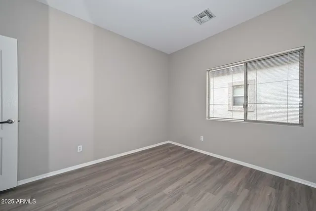 wooden floor in an empty room with a window
