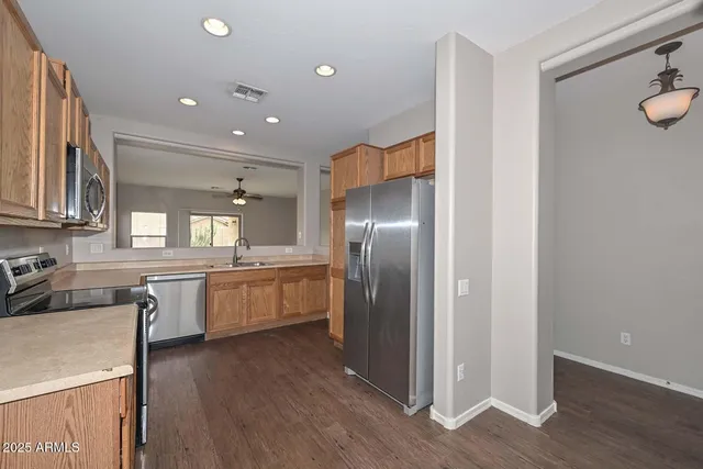 a large kitchen with a wooden floor and cabinets