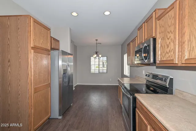 a kitchen with stainless steel appliances granite countertop a refrigerator a stove and a wooden floors