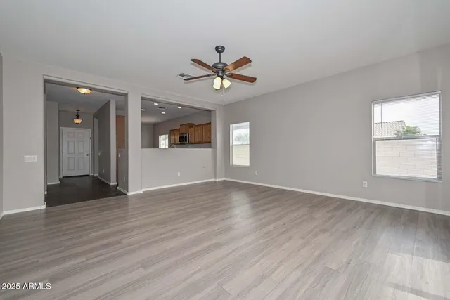 a view of a livingroom with a window and wooden floor