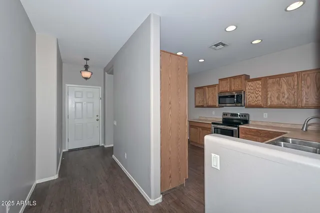 a view of a kitchen with a sink a refrigerator and cabinet