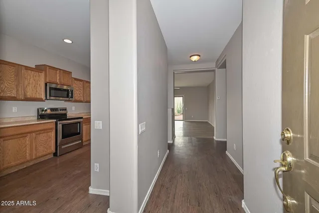 a view of a kitchen with a sink stove cabinets and empty room