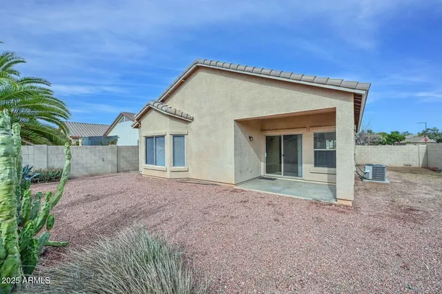 a view of house with backyard and bushes
