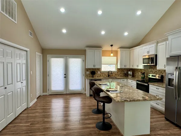 a kitchen with stainless steel appliances granite countertop a sink stove and refrigerator