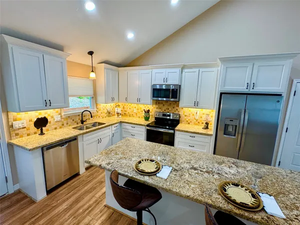 a kitchen with stainless steel appliances granite countertop a sink stove and refrigerator