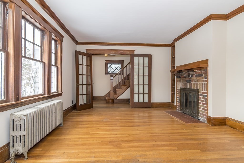 299 Weston Road Wellesley, MA 02482 - Photo 5 of 22 a view of an empty room with wooden floor fireplace and a window