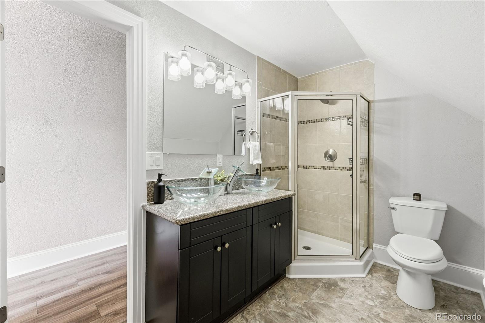 3324 Franklin Street Denver, CO 80205 - Photo 27 of 50 a bathroom with a toilet a sink and glass door