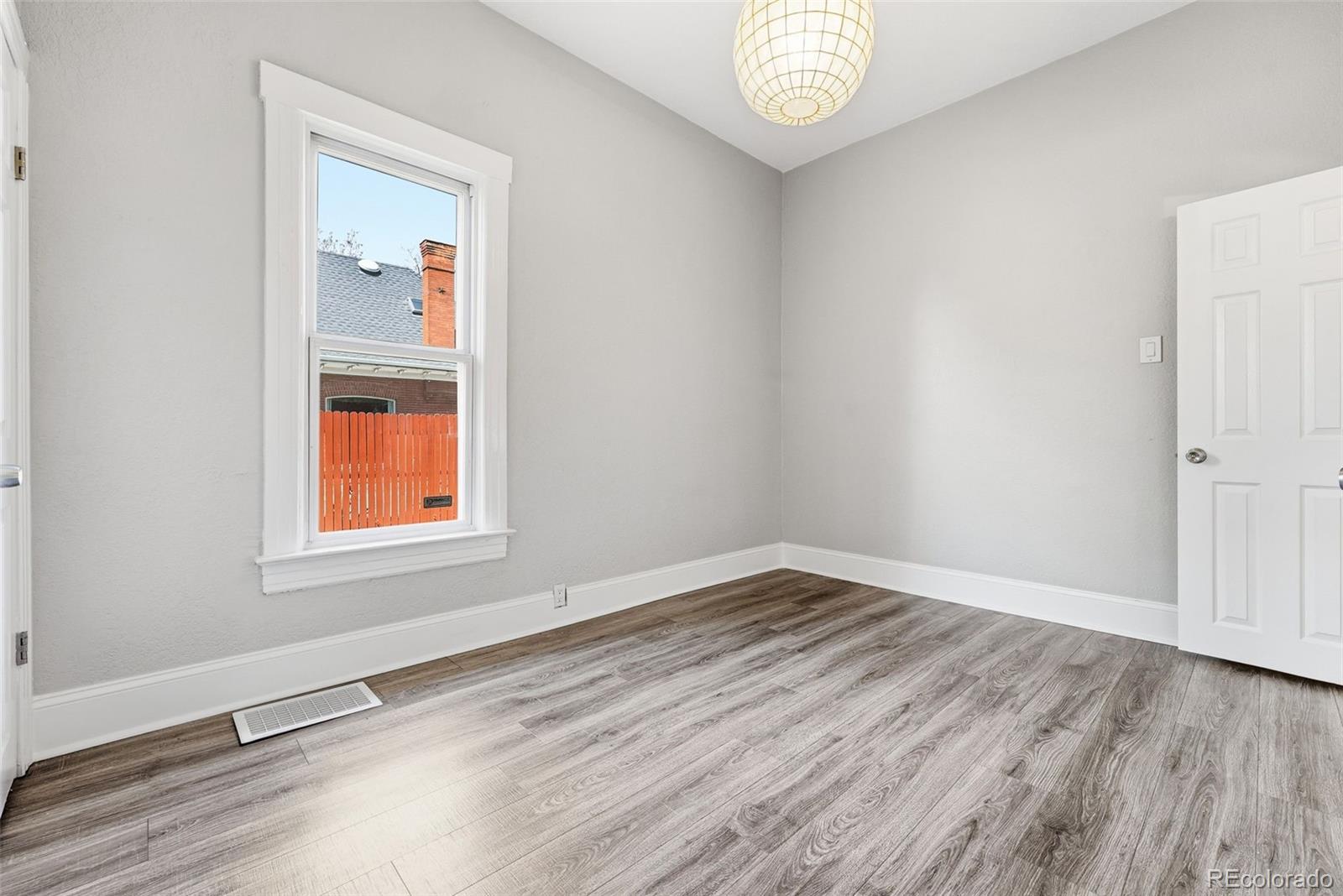 3324 Franklin Street Denver, CO 80205 - Photo 32 of 50 an empty room with wooden floor and windows