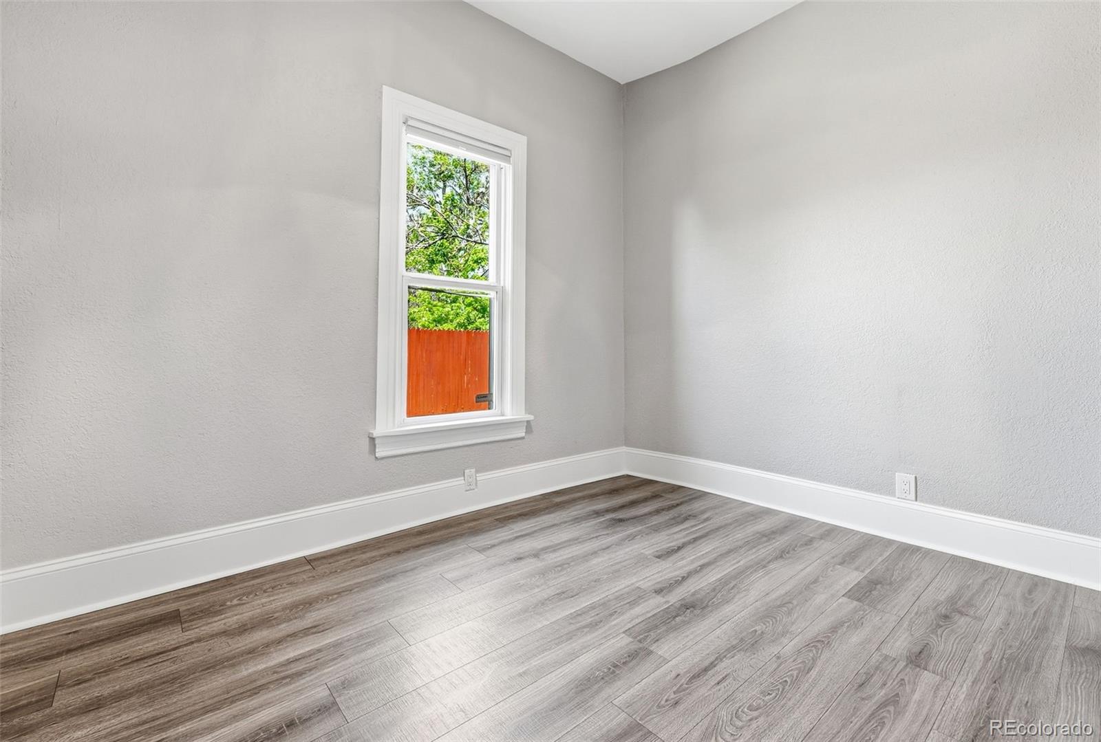 3324 Franklin Street Denver, CO 80205 - Photo 33 of 50 a view of an empty room with wooden floor and a window