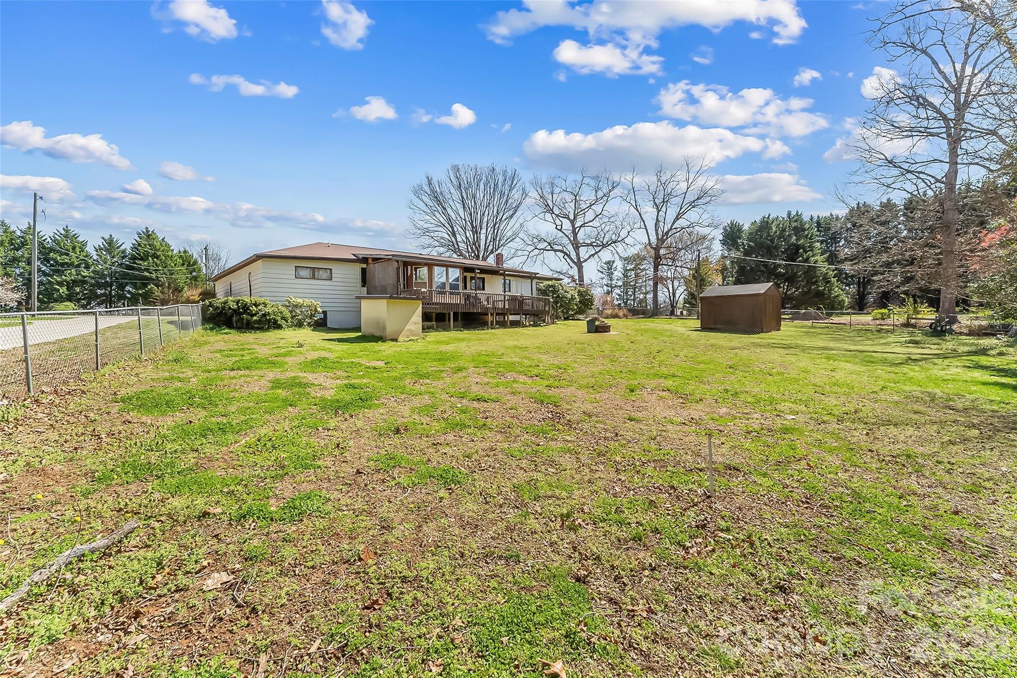 2706 Connelly Springs Road Granite Falls, NC 28630 - Photo 29 of 34 a tall yellow house with a big yard and large trees