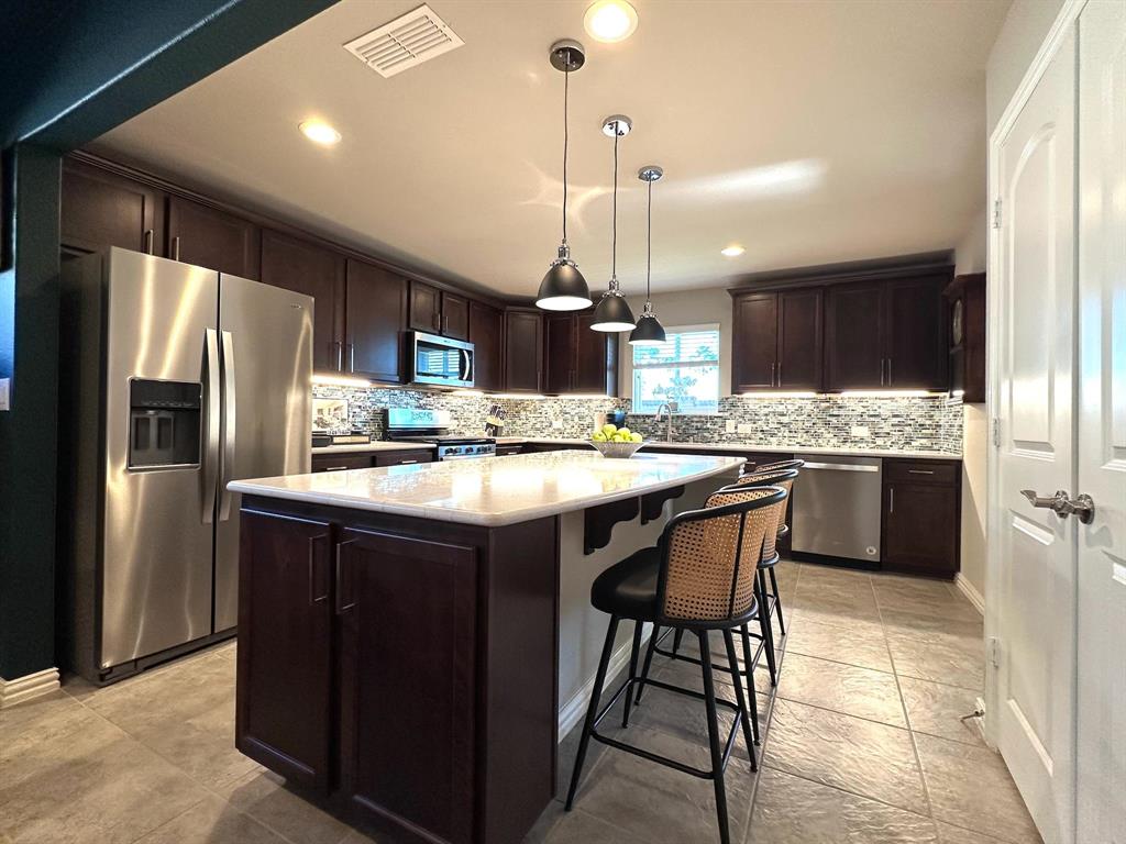 1884 Marsh Point Drive Frisco, TX 75036 - Photo 3 of 23 a kitchen with a refrigerator a sink and wooden cabinets