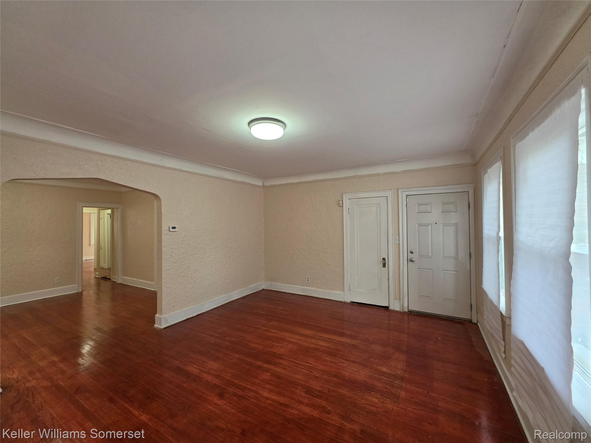 12609 Santa Rosa Drive Detroit, MI 48238 - Photo 3 of 11 Hardwood flooring, arched doorway, textured walls, flush mount lighting, and white trim