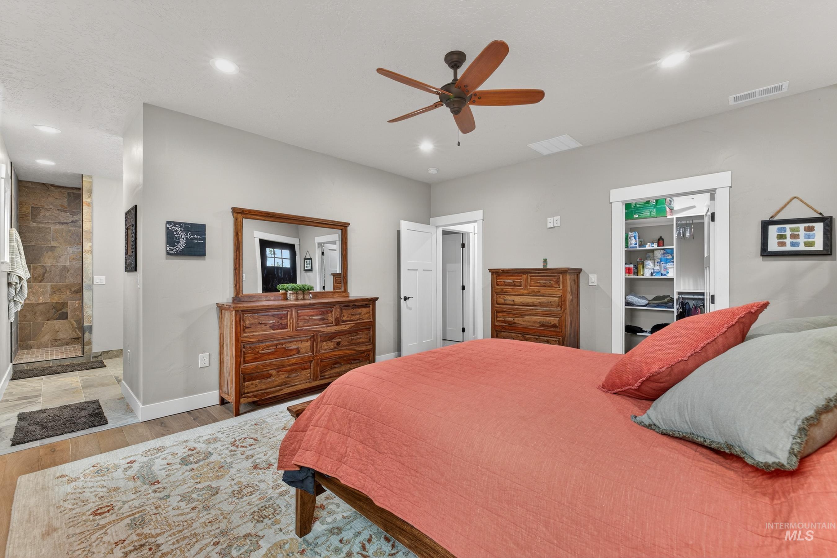 10191 Timberrim Drive Cascade, ID 83611 - Photo 24 of 44 Bedroom featuring light wood finished floors, a spacious closet, a ceiling fan, recessed lighting, and connected bathroom