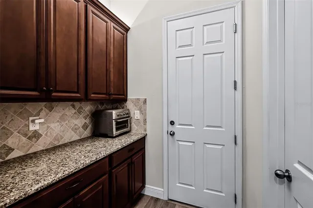 a kitchen with granite countertop white cabinets and sink
