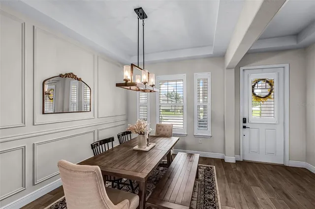 a dining room with furniture a chandelier and wooden floor