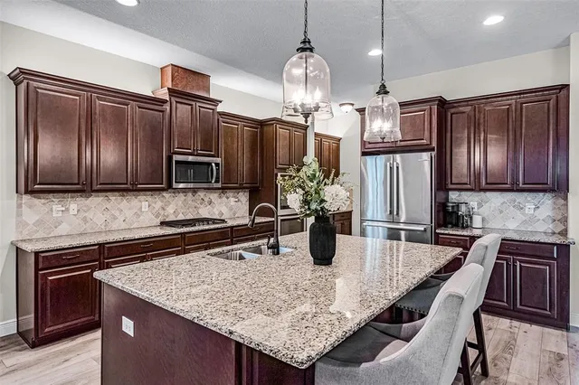 a kitchen with stainless steel appliances granite countertop a sink refrigerator and microwave